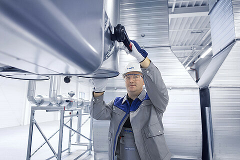 Leadec employee working on the ventilation system of a factory.