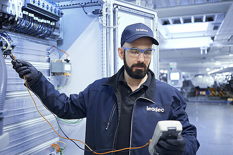 A Leadec employee analyzing faults and repairing installed electronics.