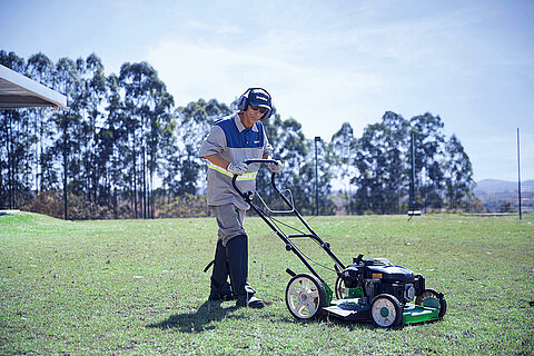 Leadec employee mows lawn on factory premises.